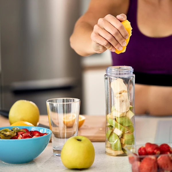 Personne préparant un smoothie aux fruits frais dans un blender