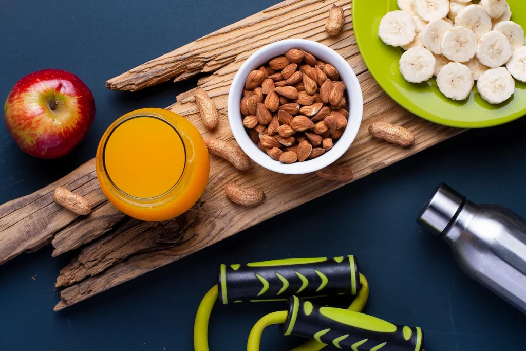 Collation énergétique avec amandes, banane, jus d’orange et pomme